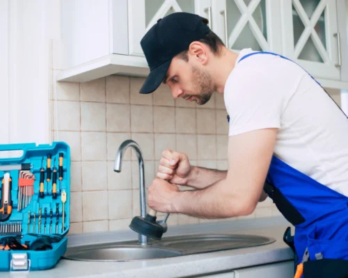 worker giving maintenance to a kitchen sync plumbing